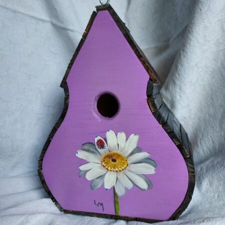 A purple birdhouse with a sunflower painted on it.